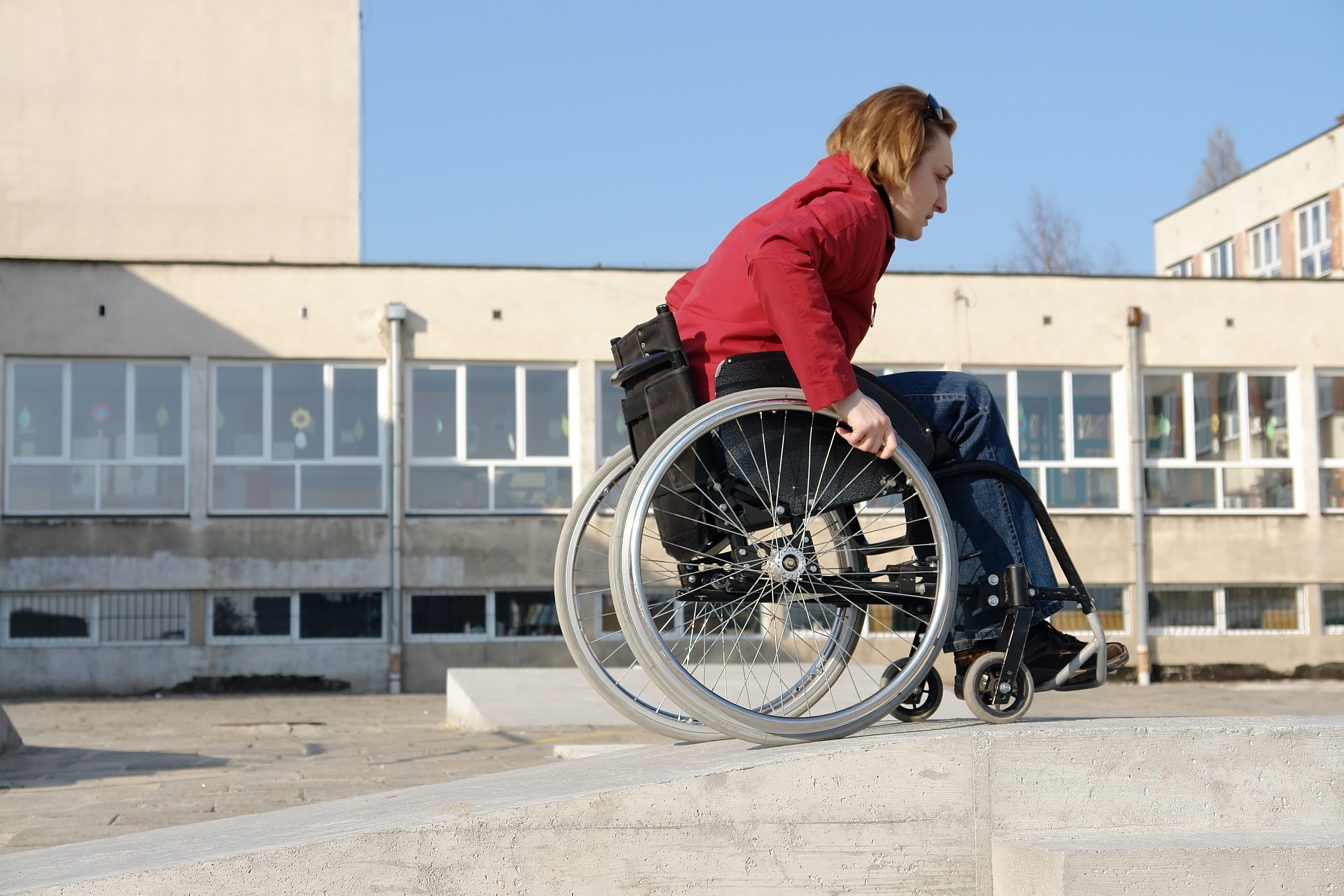 Mujer en silla de ruedas paseando por la calle frente a un edificio
