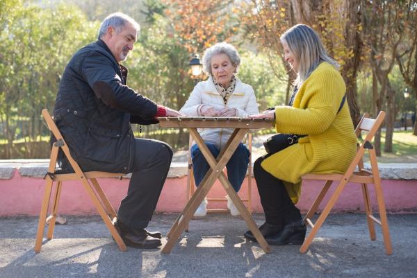 Tres personas sentadas a una mesa al aire libre