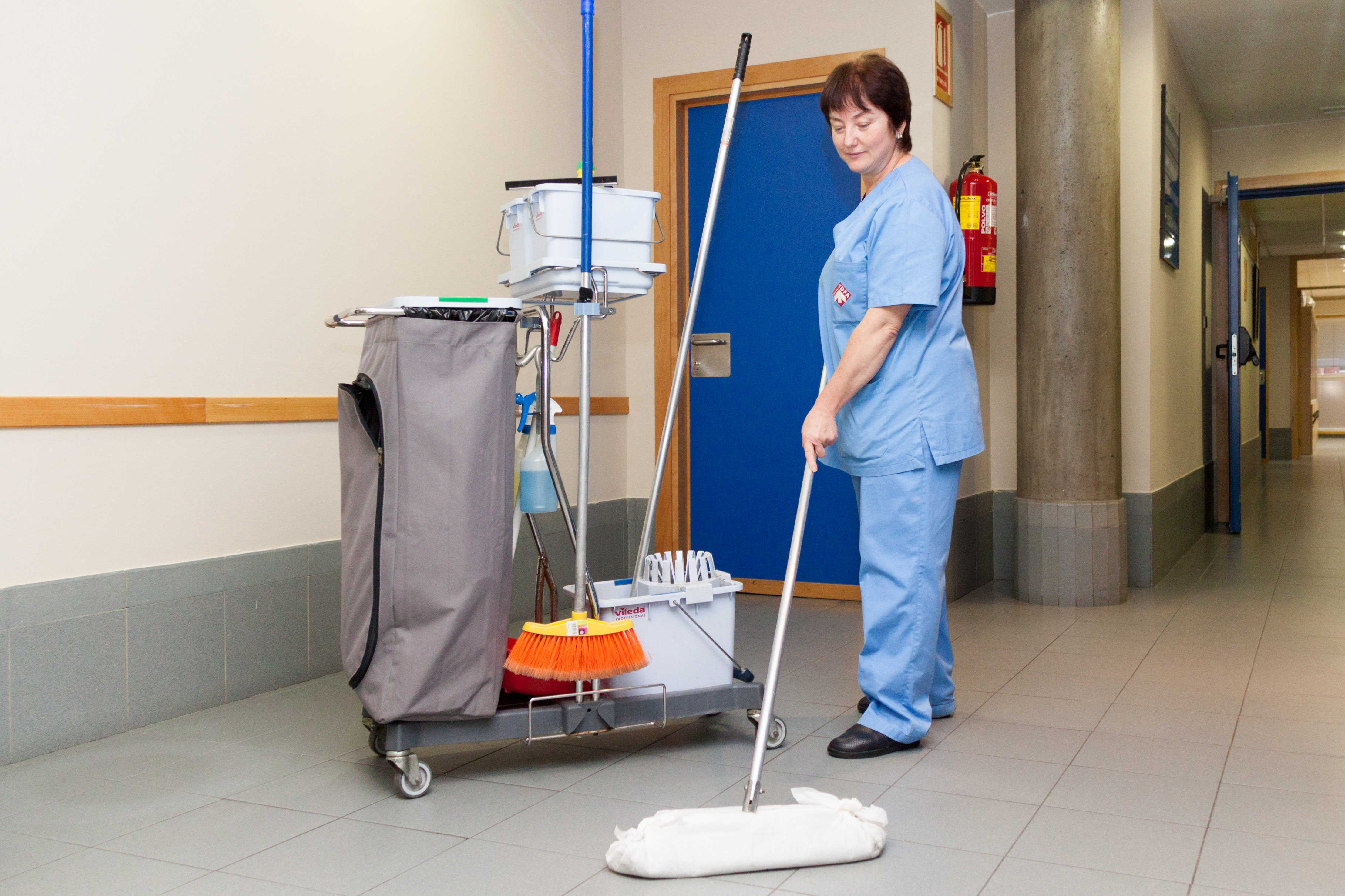 Mujer limpiando un pasillo de una empresa