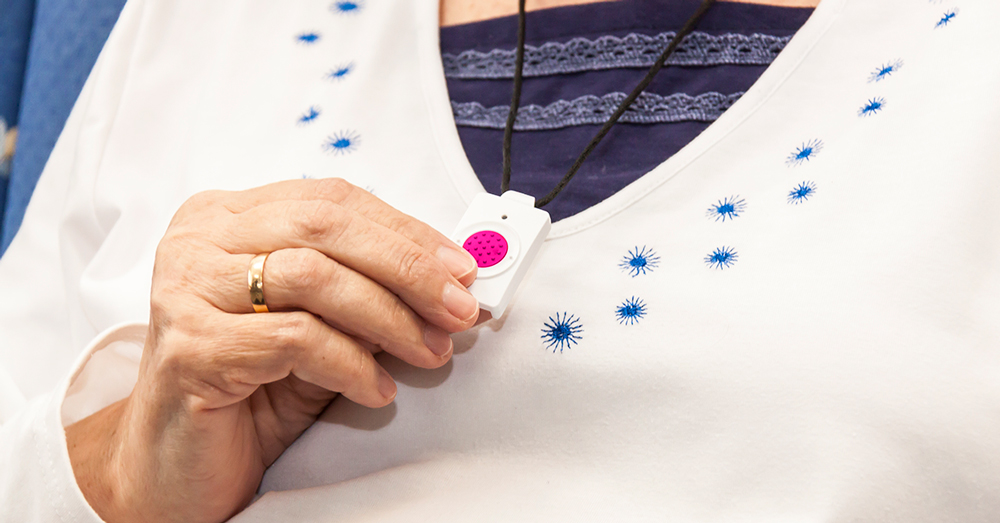 Mujer mayor sujetando un botón de teleasistencia