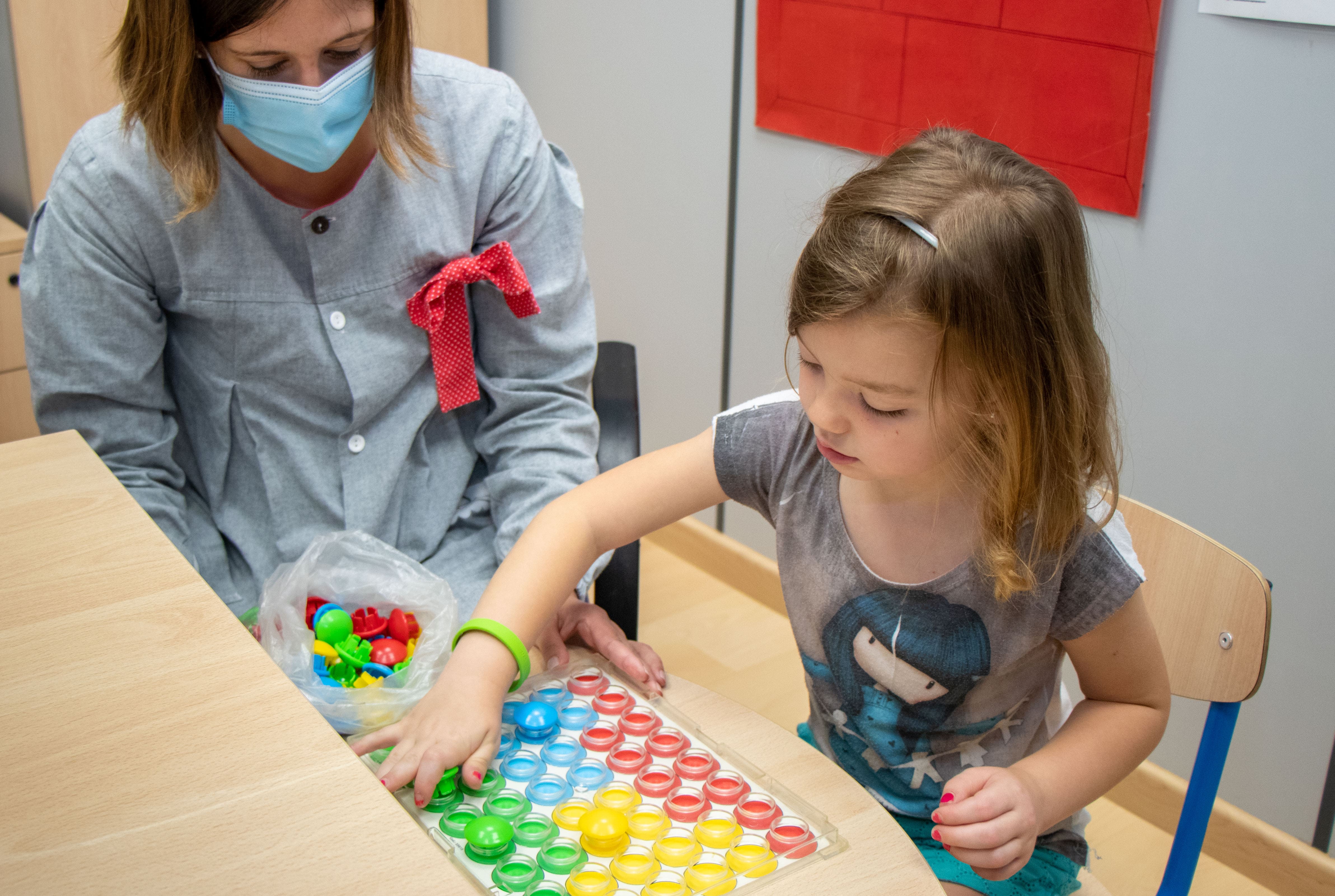 Niña jugando con una terapeuta