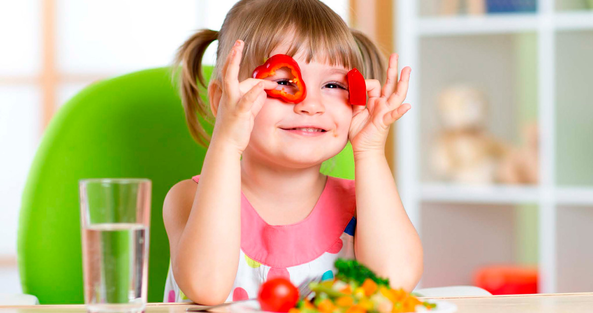 Un niña jugando con rodajas de pimiento