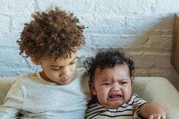 Un niño consuela a un bebé llorando