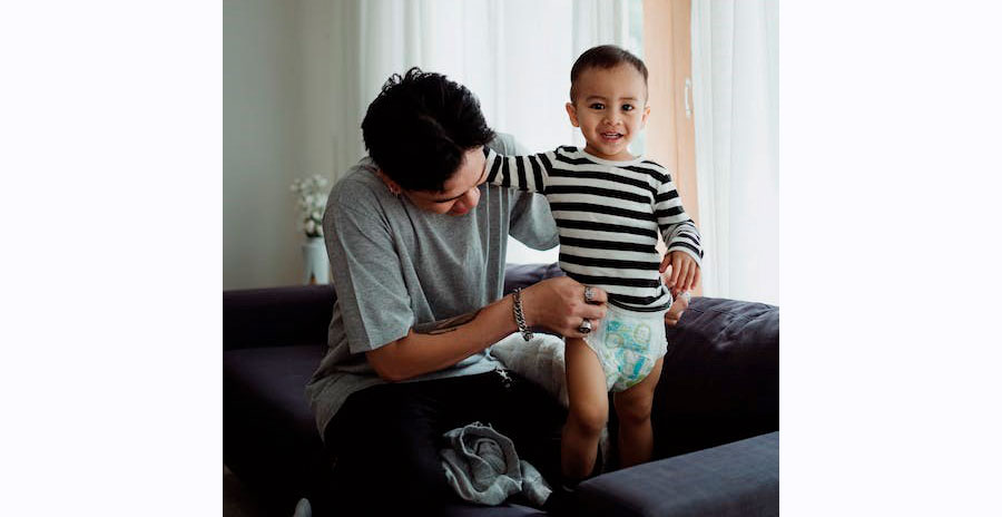 Padre toca el pañal de su hijo