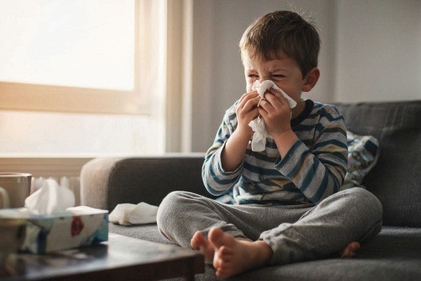 Un niño sonándose la nariz