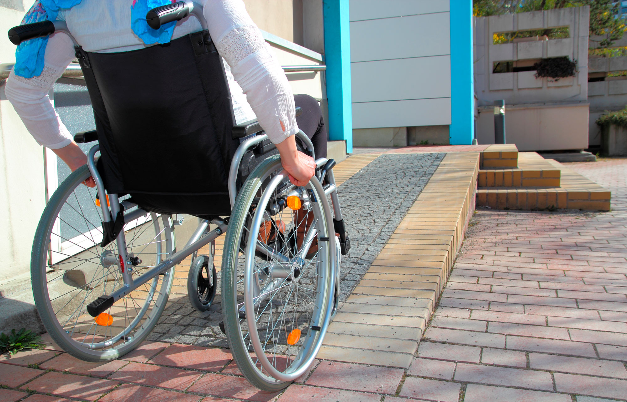 Persona sube una rampa en silla de ruedas