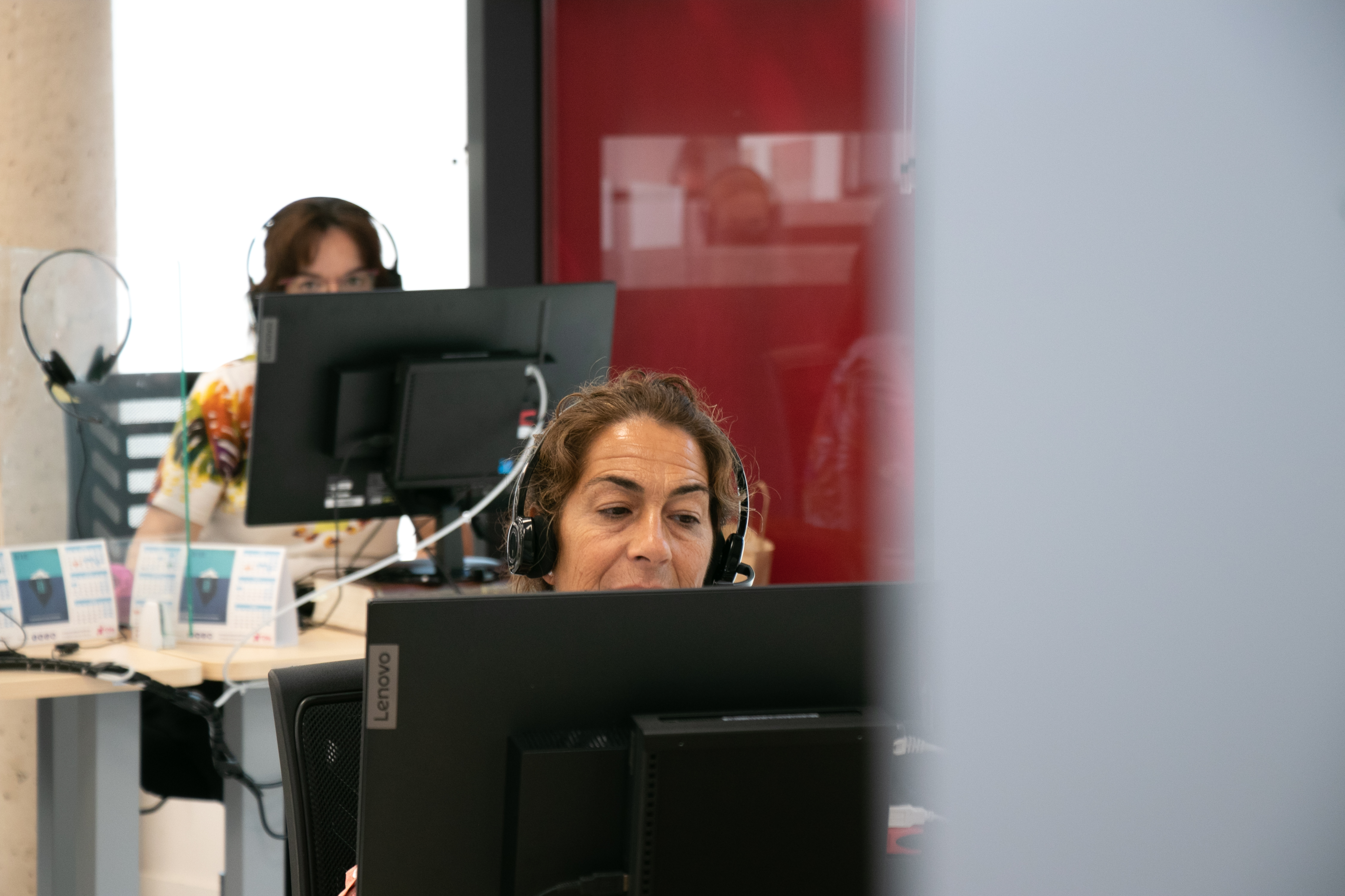La imagen muestra a dos trabajadoras del Centro de Atención Telefónica de Fundación Dfa en sus puestos de trabajo