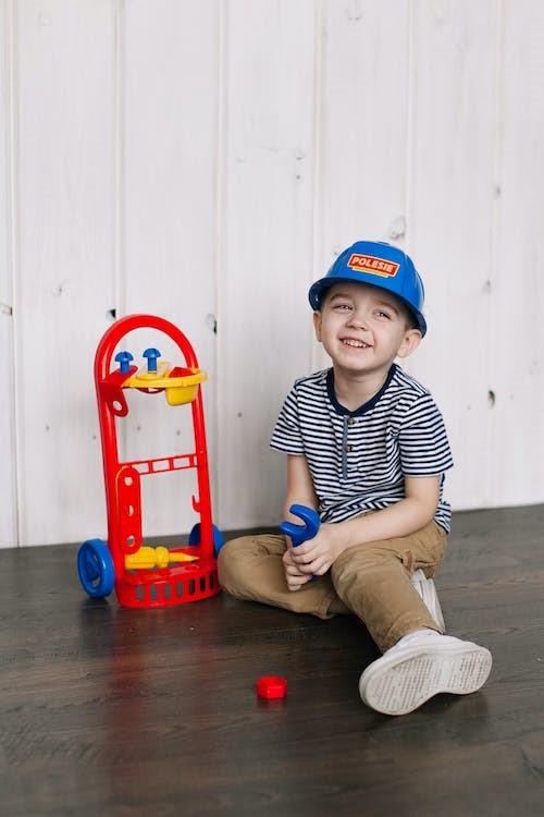 Un niño sonríe junto a un juguete