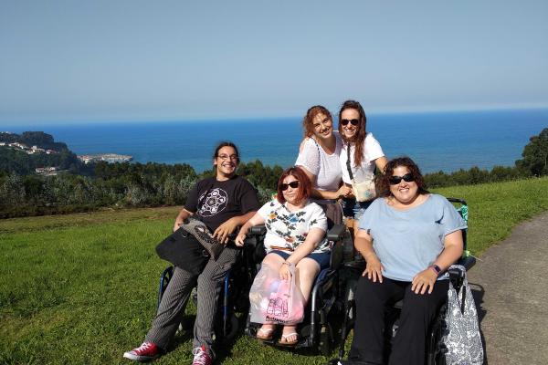 Grupo de personas con discapacidad en una colina frente al mar