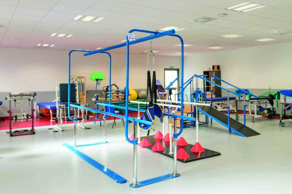 Sala de un gimnasio de rehabilitación y fisioterapia equipado con diferentes máquinas y aparatos