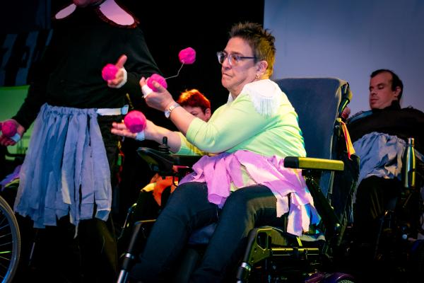Personas usuarias de silla de ruedas participando en la escena de los malabares