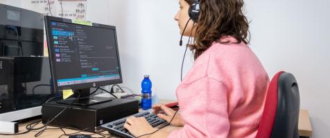 Mujer con discapacidad visual delante del ordenador trabajando como operadora de Atención telefónica en el call center de Dfa