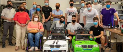 Alumnos del Centro San Valero junto a dos coches eléctricos infantiles con su profesor y miembros de Dfa