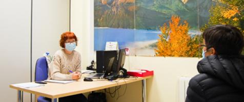 Mujer atendiendo a una usuaria en un despacho