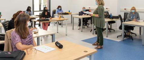 Imagen de una profesora dando clase en un aula