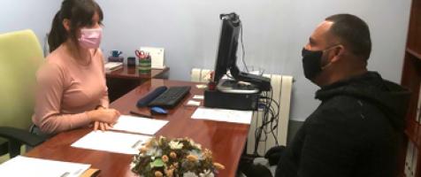 Mujer atendiendo a un usuario en un despacho