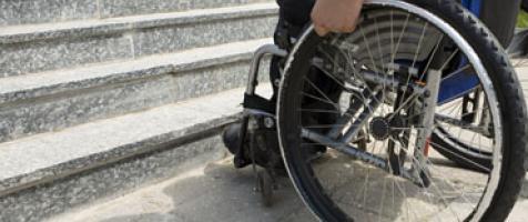 Persona en silla de ruedas ante unas escaleras