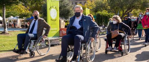 Personas en silla de ruedas paseando por el mercadillo agroalimentario de Unizar