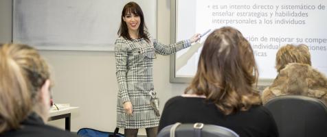 Una profesora da clases a varias personas durante un curso en Dfa