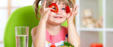 Niña juega con pimientos