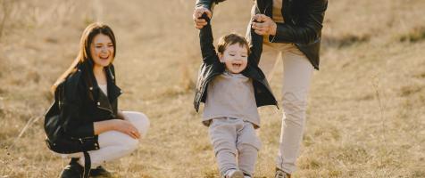 Un niño jugando al aire libre con sus padres