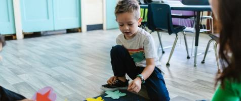 Un niño juega en clase con figuras geométricas
