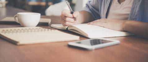 Varios cuadernos y dispositivos móviles encima de una mesa de oficina