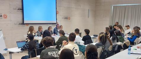Imagen del aula magna de la universidad san jorge con el alumnado de espaldas en primer plano y los especialistas al fondo