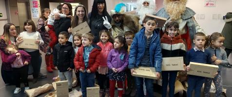 La imagen muestra a los Reyes Magos en el 'hall' del edificio Josemi Monserrate rodeados de niños y niñas del servicio de Desarrollo Infantil. Les acompaña Desirée Garrido, directora del servicio, y de Myriam Carrel, directora de NETT Digital School