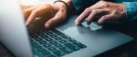 Un portátil con las manos de una persona que lo maneja