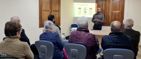 Personas en grupo atendiendo una charla en una sala de Cantavieja