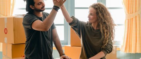 Una pareja choca las manos rodeada de cajas