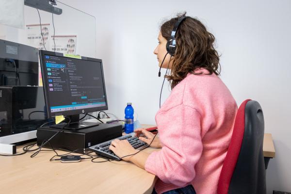 Mujer con discapacidad visual delante del ordenador trabajando como operadora de Atención telefónica en el call center de Dfa