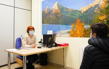 Mujer atendiendo a una usuaria en un despacho