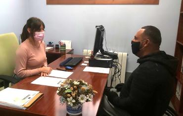 Mujer atendiendo a un usuario en un despacho