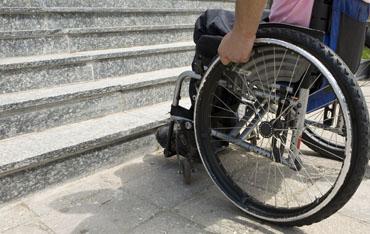 Persona en silla de ruedas ante unas escaleras