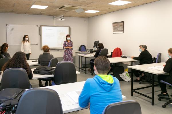 Una mujer imparte un taller ante alumnos y alumnas sentadas en sus mesas