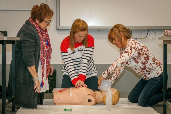 Tres personas realizan una práctica de una taller sanitario