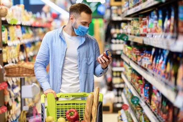 Un hombre mira el etiquetado de un alimento en el supermercado
