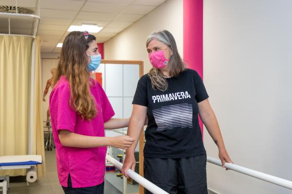 Una paciente realiza un ejercicio acompañada de la rehabilitadora