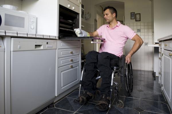 Un usuario de silla de ruedas en la cocina de su casa