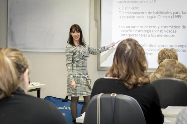 Una profesora da clases a varias personas durante un curso en Dfa