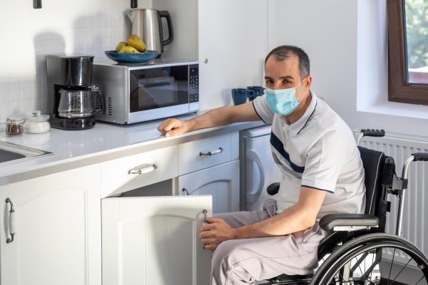 Hombre en silla de ruedas en la cocina