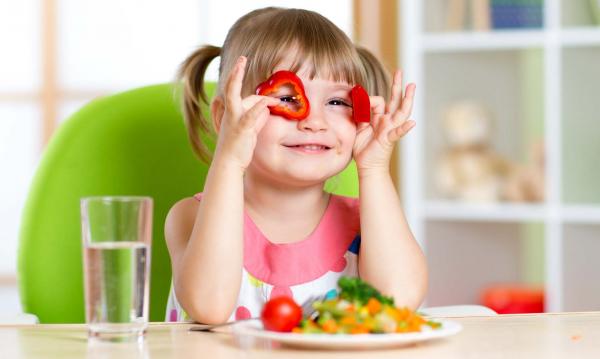 Niña juega con pimientos