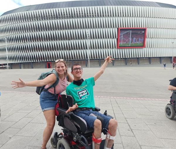 Una voluntaria y un usuario, frente al estadio de San Mamés.