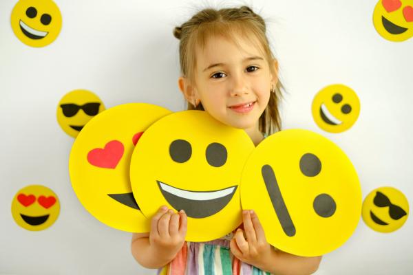 Una niña con varias caras de emojis