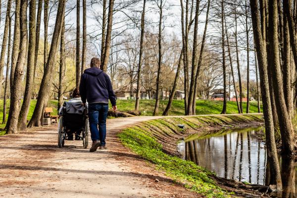 Una persona en silla de ruedas pasea por un camino acompañada de otra