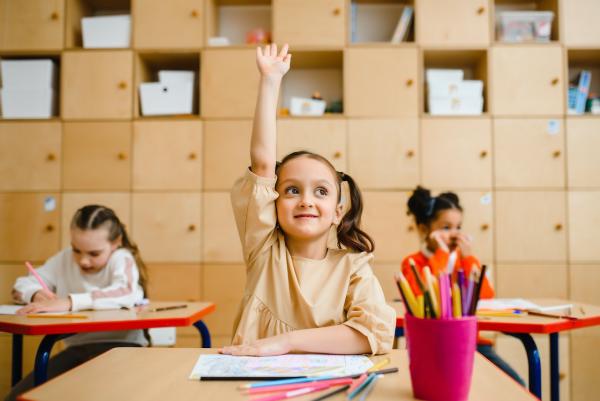Una niña levanta la mano en una clase