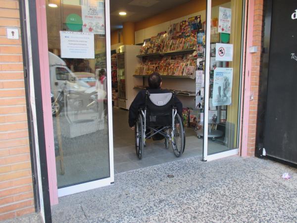 Una persona en silla de ruedas entra a un establecimiento