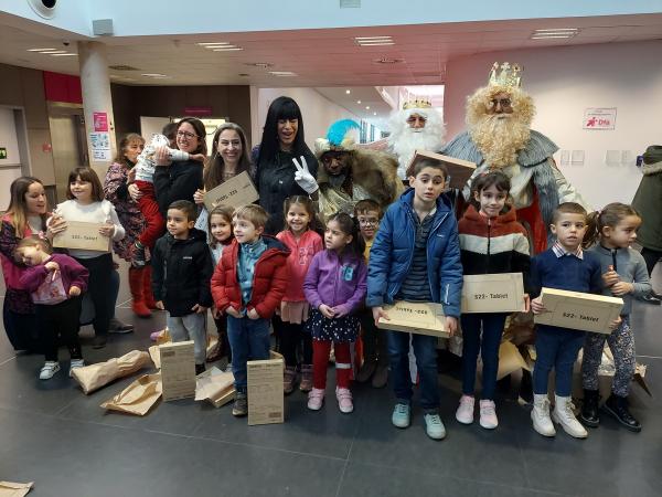 La imagen muestra a los Reyes Magos en el 'hall' del edificio Josemi Monserrate rodeados de niños y niñas del servicio de Desarrollo Infantil. Les acompaña Desirée Garrido, directora del servicio, y de Myriam Carrel, directora de NETT Digital School